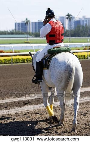 Rear view of a jockey riding a horse View Large Photo Image Stock Image - Rear view of a jockey riding a horse. Fotosearch
