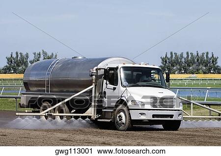Stock Image - Truck spraying insecticide on crop in a field. Fotosearch