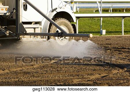 Truck spraying water on a horseracing track View Large Photo Image Stock Photo - Truck spraying water on a horseracing track. Fotosearch