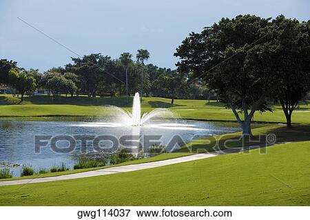 Fountain in a golf course View Large Photo Image Stock Photo - Fountain in a golf course. Fotosearch