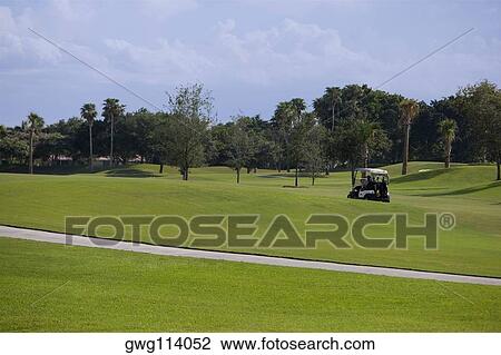 Stock Image - Golf cart in a golf course. Fotosearch