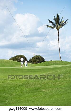 Rear view of a man and a woman in a golf course View Large Photo Image Stock Photo - Rear view of a man and a woman in a golf course. Fotosearch