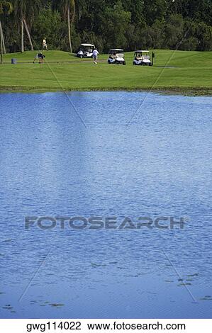 Three men playing golf in a golf course View Large Photo Image Stock Image - Three men playing golf in a golf course. Fotosearch