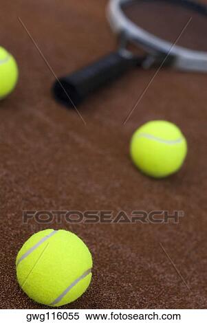 Close-up of three tennis balls and a racket in a court View Large Photo Image Stock Photography - Close-up of three tennis balls and a racket in a court. Fotosearch