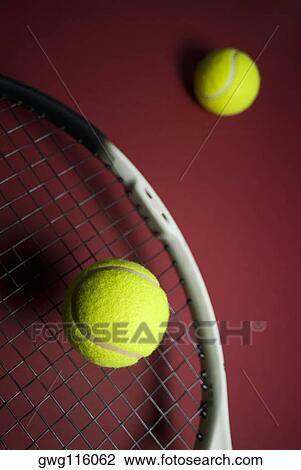 Stock Image - Close-up of two tennis balls and a tennis racket. Fotosearch