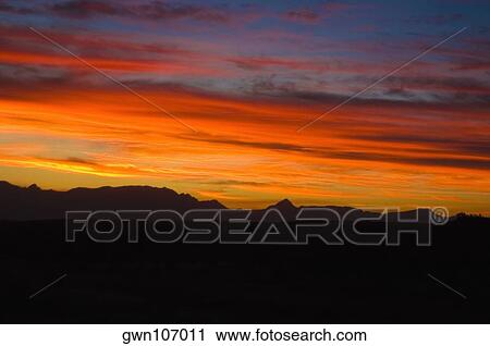 Stock Image - Clouds over mountains at sunset, Drakensberg, South Africa. Fotosearch