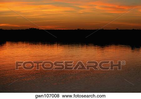 Orange glow of the sky in water at sunset, Okavango Delta, Botswana View Large Photo Image Stock Photo - Orange glow of the sky in water at sunset, Okavango Delta, Botswana. Fotosearch