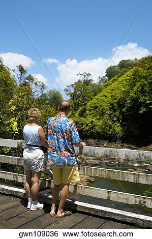 Rear view of a man and a woman looking at a view, Onemea Bay, Big Island, Hawaii Islands, USA View Large Photo Image Stock Photograph - Rear view of a man and a woman looking at a view, Onemea Bay, Big Island, Hawaii Islands, USA. Fotosearch