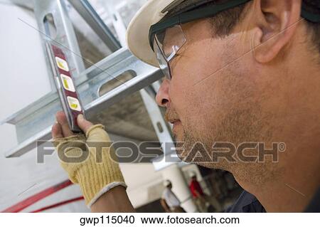 Close-up of a male construction worker using a spirit level View Large Photo Image Stock Image - Close-up of a male construction worker using a spirit level. Fotosearch