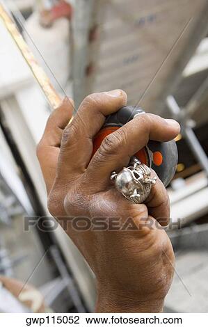 Close-up of a man's hand holding a tape measure View Large Photo Image Stock Image - Close-up of a man's hand holding a tape measure. Fotosearch