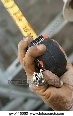 Close-up of a person's hand holding a tape measure View Large Photo Image Stock Image - Close-up of a person's hand holding a tape measure. Fotosearch