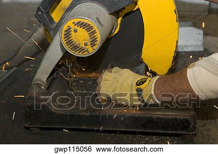 Stock Photograph - Close-up of a person's hands using an electric saw. Fotosearch