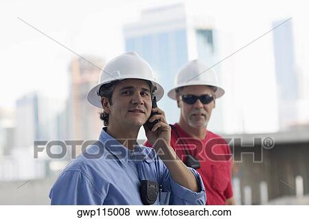Stock Photo - Close-up of two male construction workers at a construction site. Fotosearch