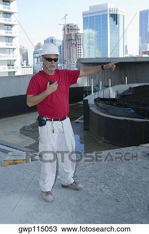 Male construction worker holding a CB radio and pointing View Large Photo Image Stock Image - Male construction worker holding a CB radio and pointing. Fotosearch