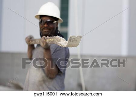 Male construction worker holding a work tool View Large Photo Image Stock Image - Male construction worker holding a work tool. Fotosearch