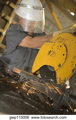 Male construction worker working on an electric saw at a construction site View Large Photo Image Stock Photograph - Male construction worker working on an electric saw at a construction site. Fotosearch