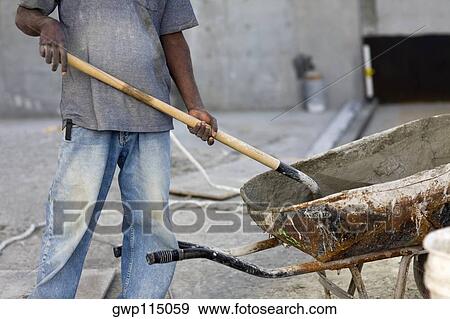 Mid section view of a male construction worker shoveling cement View Large Photo Image Stock Photo - Mid section view of a male construction worker shoveling cement. Fotosearch