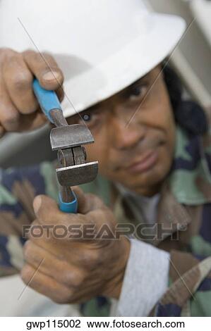 Portrait of a mature man holding a wire cutter View Large Photo Image Stock Image - Portrait of a mature man holding a wire cutter. Fotosearch