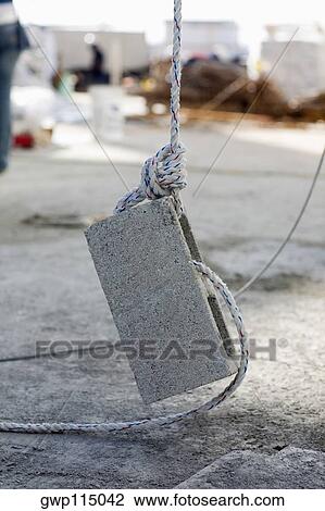 Stock Image - Rope tightened on a concrete block. Fotosearch