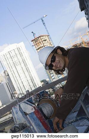 Side profile of a male construction worker working at a construction site View Large Photo Image Stock Image - Side profile of a male construction worker working at a construction site. Fotosearch