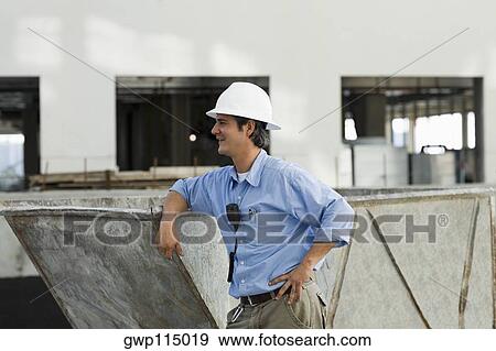 Side profile of an engineer leaning against an industrial equipment View Large Photo Image Stock Photo - Side profile of an engineer leaning against an industrial equipment. Fotosearch