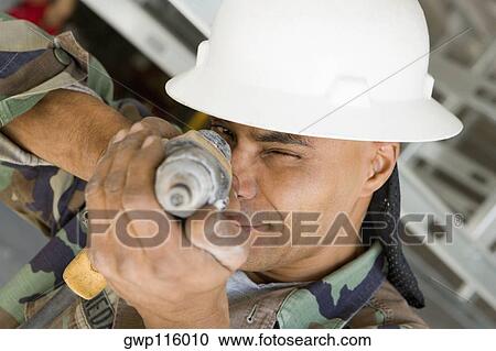 Close-up of a male construction worker aiming with a hand drill View Large Photo Image Stock Image - Close-up of a male construction worker aiming with a hand drill. Fotosearch