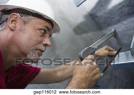 Close-up of a male construction worker cutting a metal sheet with a saw View Large Photo Image Stock Image - Close-up of a male construction worker cutting a metal sheet with a saw. Fotosearch