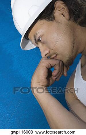 Close-up of a male construction worker thinking View Large Photo Image Stock Photo - Close-up of a male construction worker thinking. Fotosearch