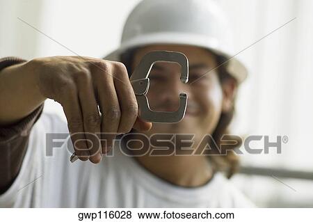 Close-up of a male construction worker holding a work tool View Large Photo Image Stock Photo - Close-up of a male construction worker holding a work tool. Fotosearch