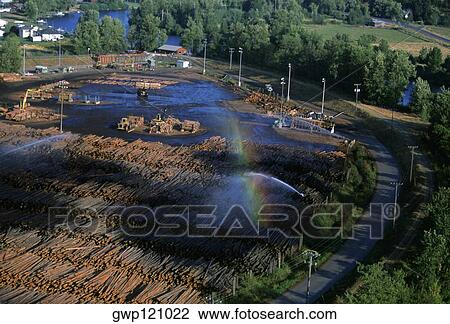 Stock Image - Watering logs to reduce heat buildup, sawmill, Idaho . Fotosearch