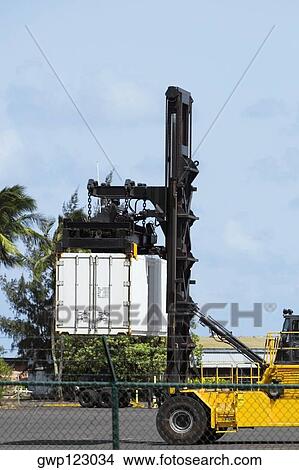 Forklift picking up a cargo container at a commercial dock View Large Photo Image Picture - Forklift picking up a cargo container at a commercial dock. Fotosearch
