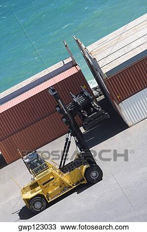 High angle view of a forklift in front of cargo containers at a commercial dock View Large Photo Image Stock Image - High angle view of a forklift in front of cargo containers at a commercial dock. Fotosearch