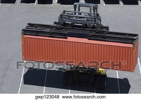 High angle view of a forklift picking up a cargo container at a commercial dock View Large Photo Image Stock Photo - High angle view of a forklift picking up a cargo container at a commercial dock. Fotosearch