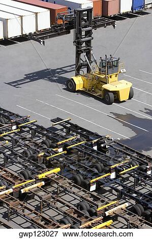 High angle view of a forklift with vehicle trailers and cargo containers at a commercial dock View Large Photo Image Stock Photo - High angle view of a forklift with vehicle trailers and cargo containers at a commercial dock. Fotosearch