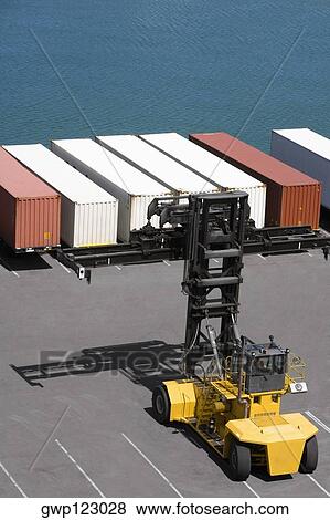 High angle view of a forklift with cargo containers at a commercial dock View Large Photo Image Stock Photo - High angle view of a forklift with cargo containers at a commercial dock. Fotosearch