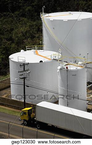 High angle view of a semi-truck on the road with storage tanks in the background View Large Photo Image Stock Image - High angle view of a semi-truck on the road with storage tanks in the background. Fotosearch