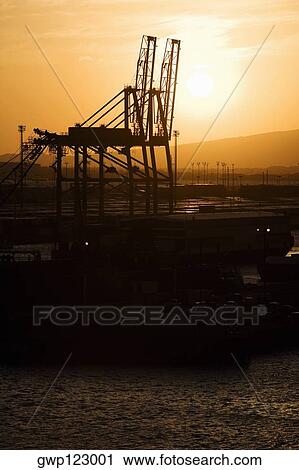 Silhouette of cranes at a commercial dock View Large Photo Image Stock Image - Silhouette of cranes at a commercial dock. Fotosearch