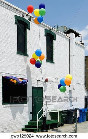 Balloon tied up with a railing in front of a building View Large Photo Image Picture - Balloon tied up with a railing in front of a building. Fotosearch