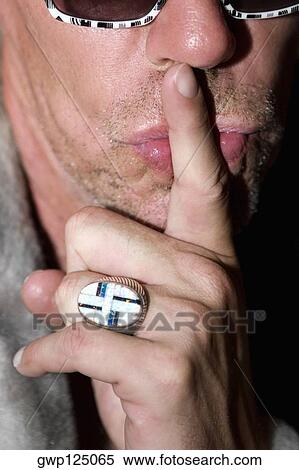 Close-up of a mature man gesturing with his finger on lips View Large Photo Image Stock Photography - Close-up of a mature man gesturing with his finger on lips. Fotosearch