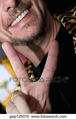Close-up of a mid adult man making a victory sign View Large Photo Image Stock Image - Close-up of a mid adult man making a victory sign. Fotosearch