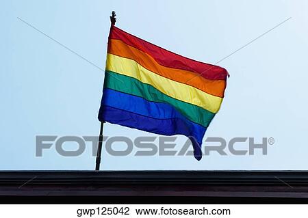 Low angle view of a rainbow flag fluttering View Large Photo Image Stock Image - Low angle view of a rainbow flag fluttering. Fotosearch