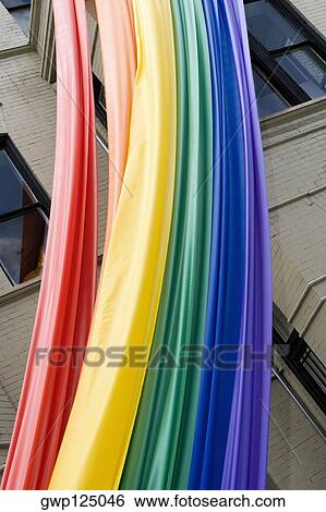 Low angle view of a rainbow flag hanging on a building View Large Photo Image Stock Photograph - Low angle view of a rainbow flag hanging on a building. Fotosearch
