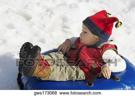 Stock Photo - Boy reclining in an inner tube. Fotosearch