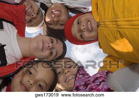 Low angle view of five children and a teenage boy standing in a circle and smiling View Large Photo Image Stock Photo - Low angle view of five children and a teenage boy standing in a circle and smiling. Fotosearch
