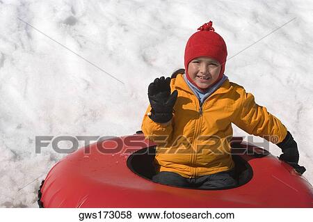 Stock Photo - Portrait of a boy sitting on an inner tube and smiling. Fotosearch
