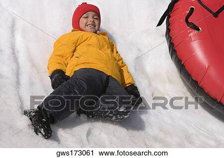 Portrait of a girl sliding with an inner tube in snow View Large Photo Image Stock Image - Portrait of a girl sliding with an inner tube in snow. Fotosearch
