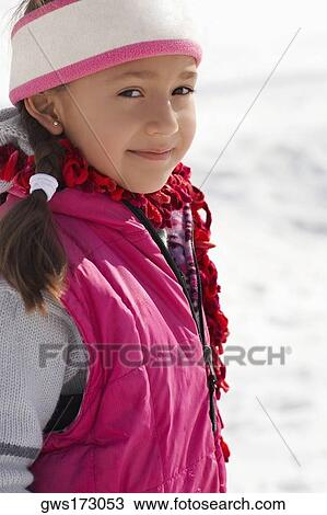 Stock Image - Portrait of a girl standing in snow. Fotosearch