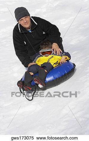 Stock Photography - Portrait of a mature man with his daughter sitting in an inflatable ring. Fotosearch