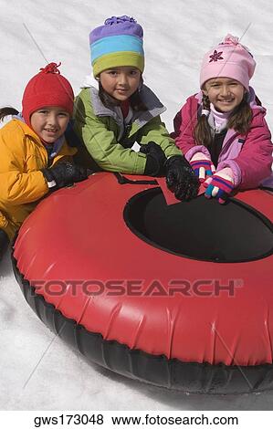 Portrait of three girls sitting near an inner tube View Large Photo Image Stock Photo - Portrait of three girls sitting near an inner tube. Fotosearch