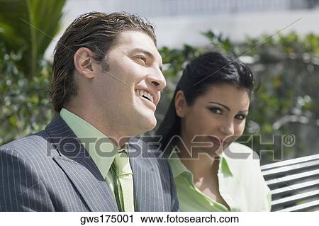 Stock Image - Close-up of a businessman smiling with a businesswoman. Fotosearch